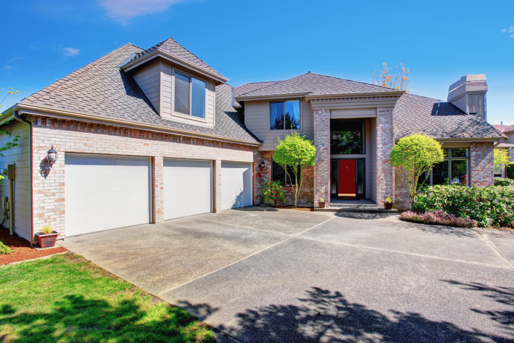 Beautiful large two story home with custom concrete driveway in daytime, greenery