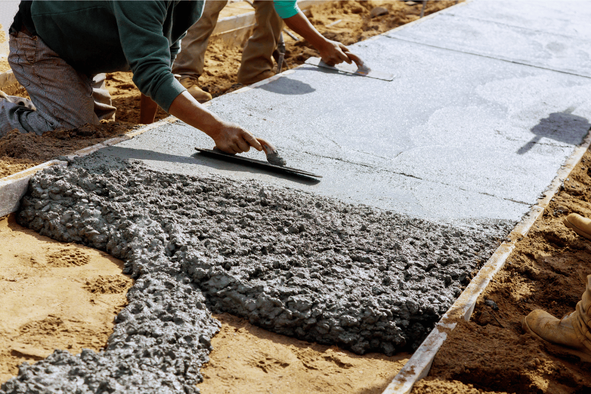 Concrete sidewalk being poured and spread
