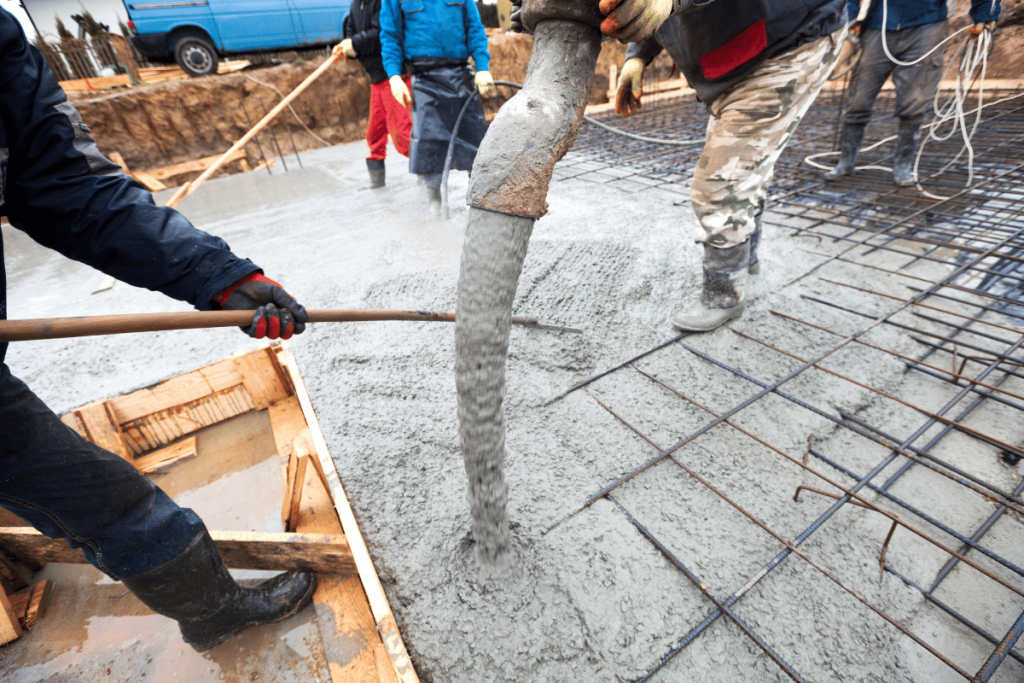 Concrete company with 5 man crew pours concrete into rebar forms