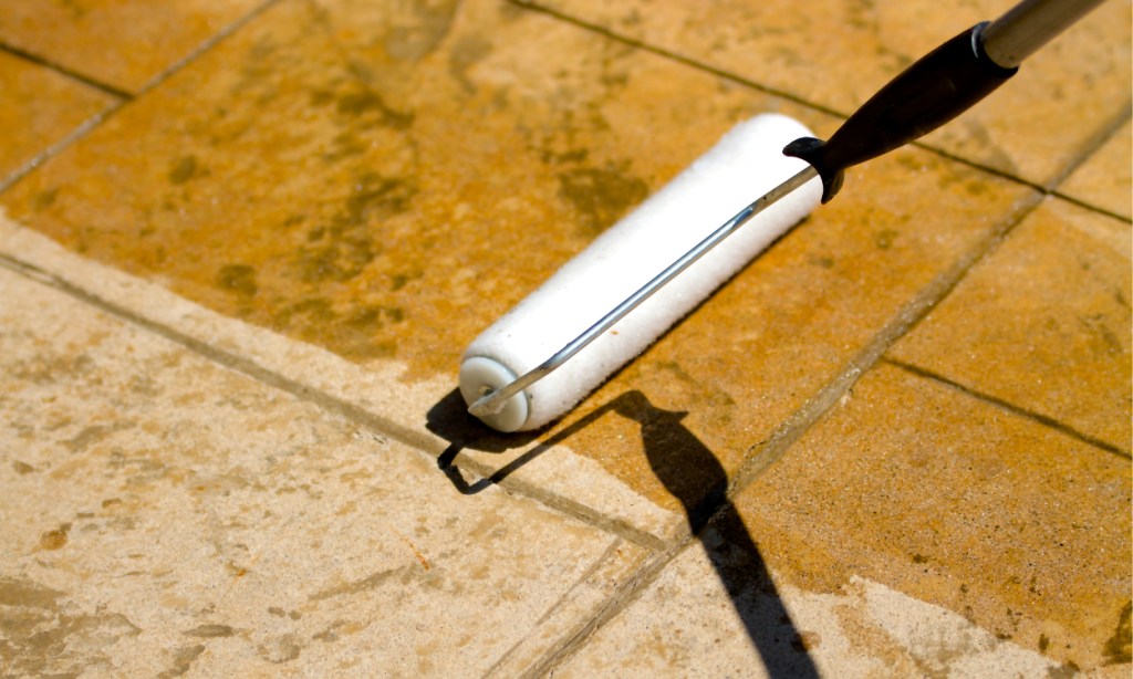 12 in paint roller spreading sealer on stamped concrete patio